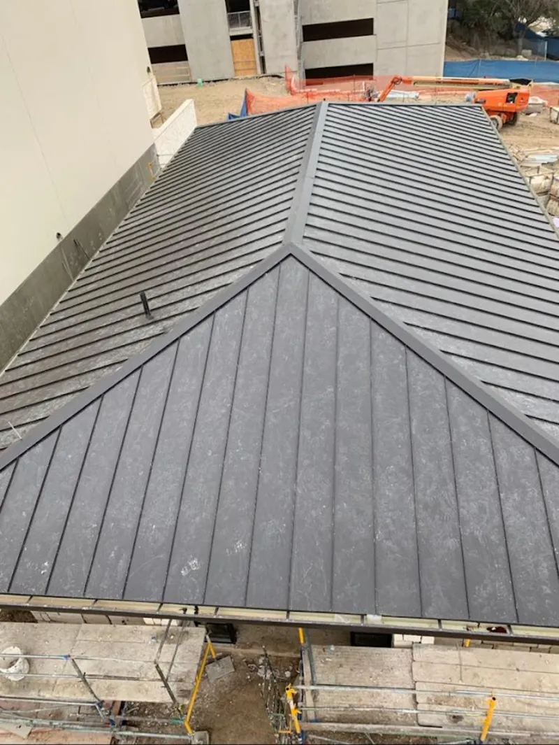 Commercial metal roof construction with crane equipment in Glendora